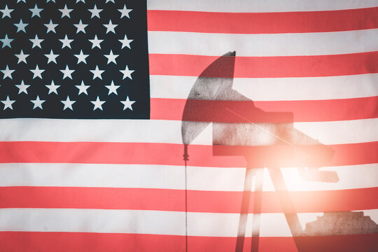 Oil pump on background of flag of usa.Silhouette oil drilling pump on background of united states flag.Double exposure.
