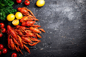 Boiled crayfish with lemon, herbs and tomatoes. 