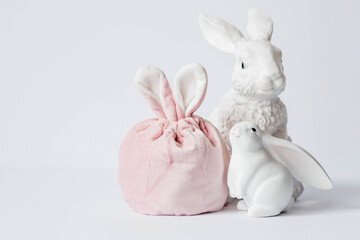 Obraz premium A beautiful postcard. Banner. The concept of a bright Easter holiday. White rabbits and Easter eggs on a white isolated background.