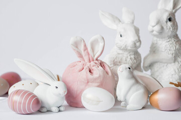 Obraz premium A beautiful postcard. Banner. The concept of a bright Easter holiday. White rabbits and Easter eggs on a white isolated background.