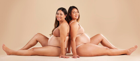 Friends, pregnancy and studio portrait for underwear, smile and women sitting together for support...