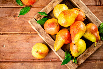 Fresh pears on a tray with leaves. 