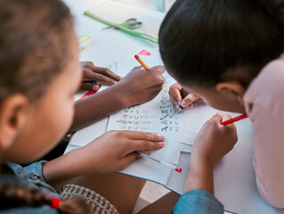 School, kids and hands writing for learning activity in group classroom together with top view. Young children and students working on literacy and academic exercises for development at desk.