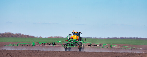 The tractor treats the soil with pesticides.
