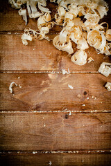 Wooden shavings on the table. On a wooden background.