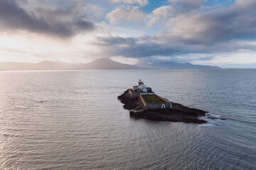 Aerial panorama view of the historic Fenit Lighthouse in Tralee Bay, beautiful clouds, sunset. High quality photo