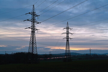 Two electric transmission towers in the Czech Republic at sunset