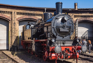 Eine Dampflok steht vor einem Tor