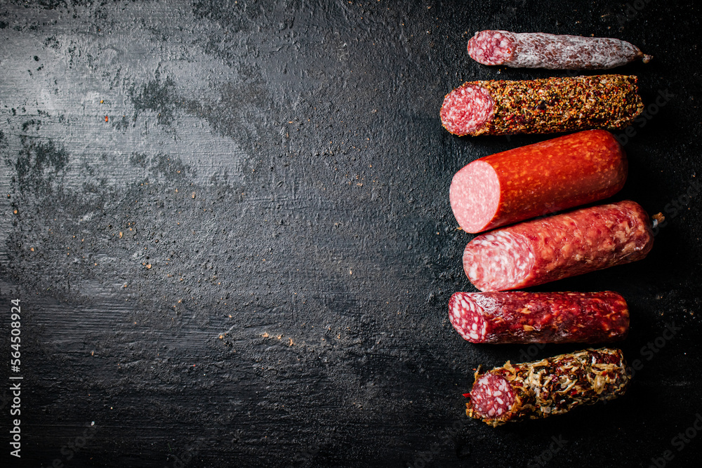 Canvas Prints Pieces of various salami sausage on the table. 