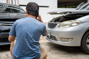 One man reporting car crash damage calling insurance and Claim roadside service