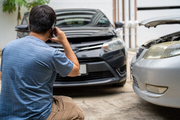 One man reporting car crash damage calling insurance and Claim roadside service