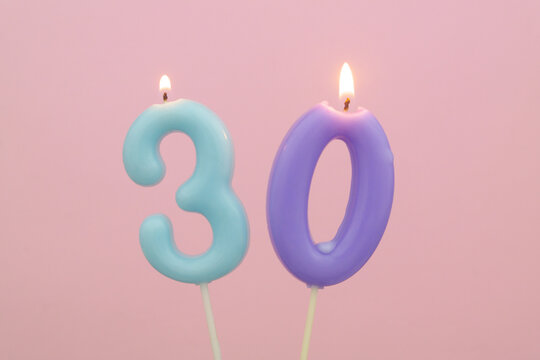 Birthday candles on pink background, number 30
