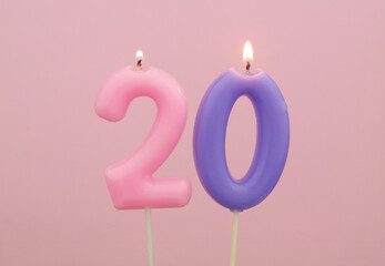 Burning birthday candles on pink, number 20