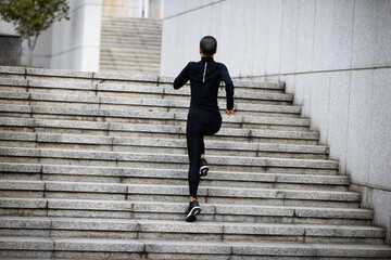 Fitness woman running up stairs in city