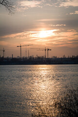 Tower cranes on abandoned area landscape photo. Beautiful nature scenery photography with sunset, river on background. Idyllic scene. High quality picture for wallpaper, travel blog, magazine, article
