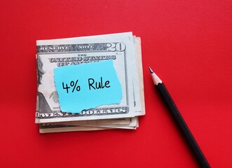 cash dollar money on red copy space background with handwritten note 4% RULE,  rule of thumb states that withdrawing and spending 4% of total fund, to make retirement savings last longer 