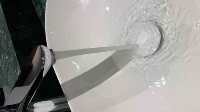 water jet faucet close-up. jet water tap stream pours. chrome faucet water steam pours in a bathroom sink. water jet running. chrome