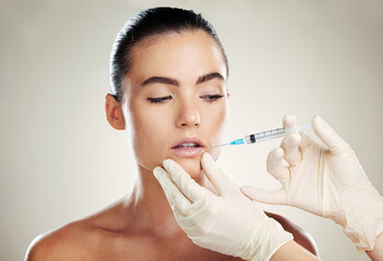 Skincare, collagen and aesthetic beauty, woman with injection in lips and treatment from healthcare professional. Mouth, needle and model with facial lip filler syringe on white background in studio