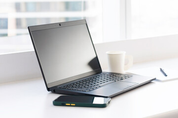Fototapeta premium Single black laptop notepad pen and mobile phone online connected via sharing hotspot ready for meeting and run project, business conception brain strom and get idea for customer.