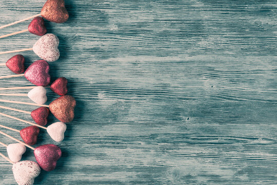 Decorative hearts on wooden rustic background with copy space. Valentine’s day greeting card template