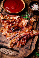 Pieces of fried bacon with tomato sauce.