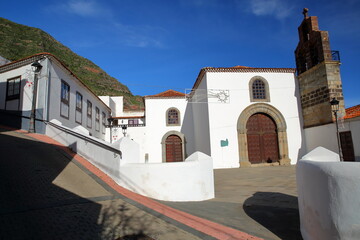 The monastic church of the Dominican monastery (El Convento de Santo Domingo) in Hermigua, La Gomera, Canary Islands, Spain, with cobbled streets and whitewashed houses - obrazy, fototapety, plakaty