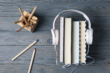 Concept of audiobook with books and headphones, top view