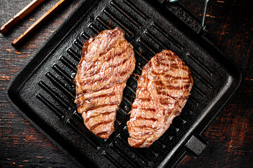 Aromatic grilled steak in a frying pan. 
