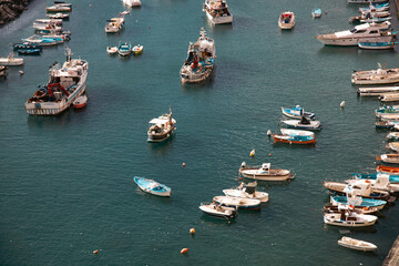 Small fishing boats in turquoise, clear water, Procida, Italy.