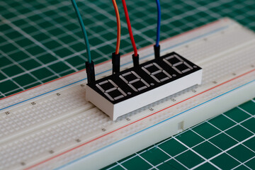 A prototyping breadboard with several components connected. This type of board is used for...