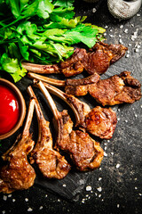 Rack of lamb with tomato sauce and parsley on the table.