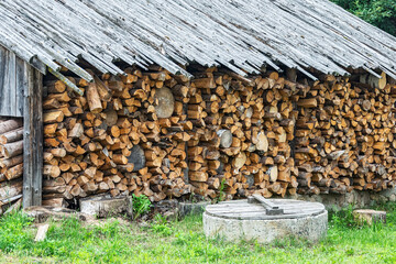 Under a canopy stacked firewood in a woodpile for the winter season
