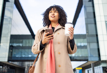 Obraz premium City walking, smartphone and black woman travel to work, corporate job or relax commute journey in New York USA. Digital mobile, architecture buildings or bottom view of girl typing on online website