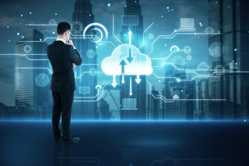 Back view of thoughtful businessman with creative cloud homputing hologram on blurry city and sky background. Database, server and information storage concept.
