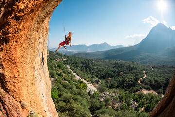Rock climber descends from the route, the climber hangs on a rope, a rock in the form of an arch,...