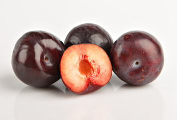 Dark blue plums isolated on white background. Fresh fruit whole and sliced. Fresh fruits.