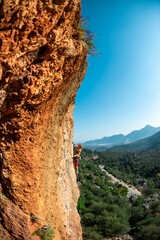 Girl climbs on the rock, rock climbing in Turkey, the sports girl is engaged in rock climbing.