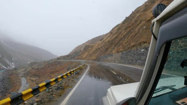 POV shot of a vehicle on a road during snowfall at Sissu village nin Lahaul Spiti district in Himachal Pradesh, India. Car on a road during the snowfall in winter season