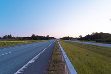 Asphalt road going into the distance on a summer evening. Space for text.
