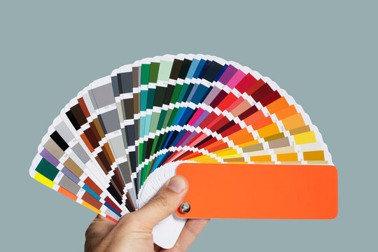 Hand holding a color palette guide, metallic color samples