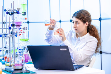 a young woman laboratory assistant fills a cuvette for growing microorganisms