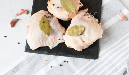 Raw chicken thighs. On a raw background. With various seasonings