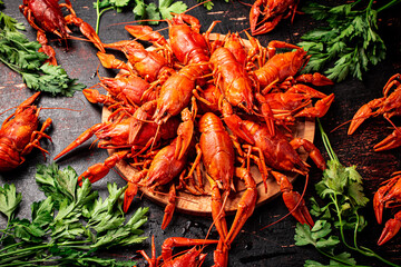 Boiled crayfish on a wooden cutting board with parsley. 