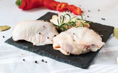 Raw chicken thighs. On a raw background. With various seasonings
