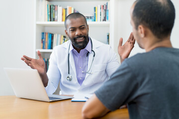 Handsome mature adult african american male doctor talking to patient