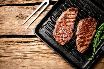 Grilled steak in a frying pan. 