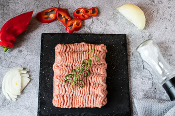 Raw minced meat with herbs and spices. on gray background