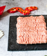 Raw minced meat with herbs and spices. on gray background