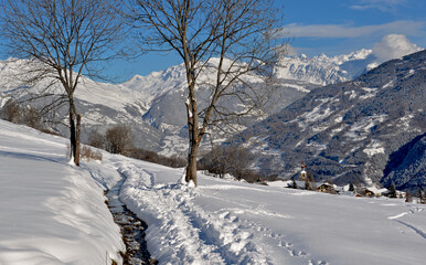 path  on the snow  with beautiful view on snowcapped mountain and alpine village