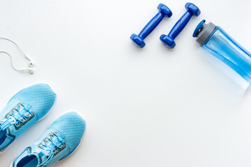 Sport background with sneakers and dumbbells, top view
